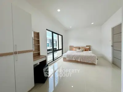 Spacious modern bedroom with large windows and sleek furnishings