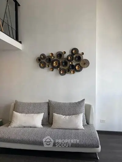 Modern living room with stylish wall art and cozy gray sofa in a contemporary apartment.