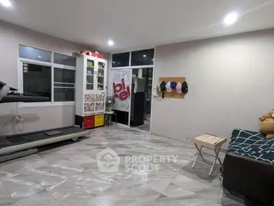 Spacious living room with modern decor and treadmill, perfect for relaxation and exercise.