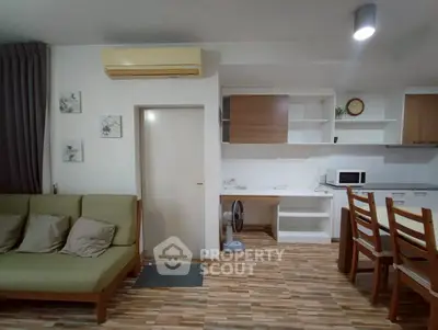 Modern open-plan living room with kitchen, featuring stylish furniture and contemporary design.