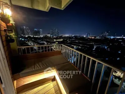 Stunning night city view from a cozy balcony with seating area.