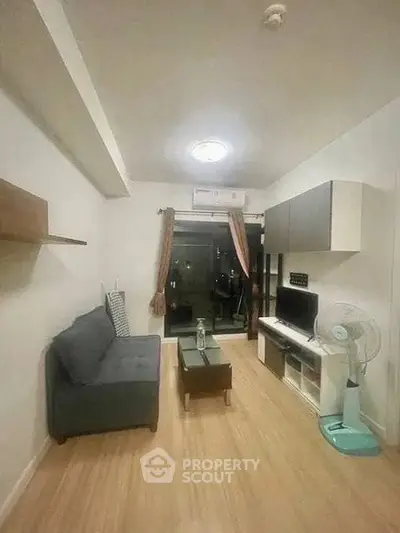 Cozy living room with modern furniture and balcony access in a stylish apartment.