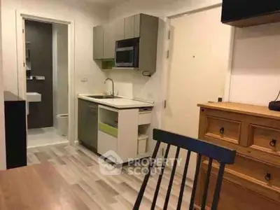 Compact studio apartment with modern kitchenette and cozy bathroom.