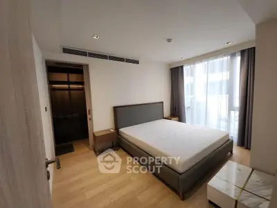 Spacious modern bedroom with large window and minimalist design in luxury apartment.