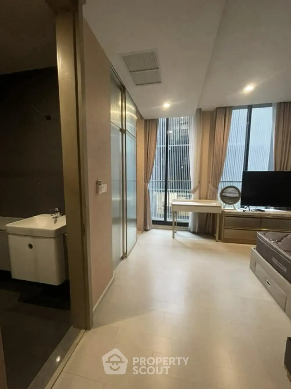 Modern apartment interior with large windows and sleek furnishings.