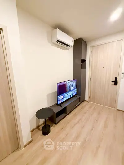 Modern living room with sleek TV setup and air conditioning unit.