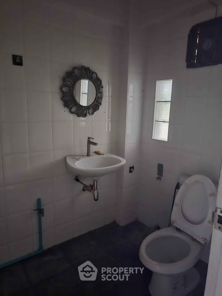 Compact bathroom with modern fixtures and stylish mirror in a cozy real estate property.