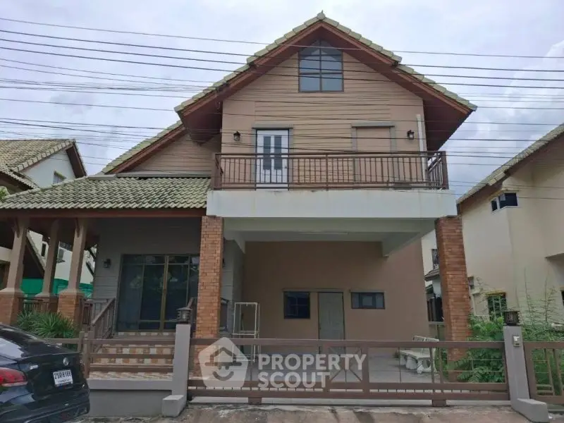 Charming two-story house with balcony and tiled roof in a serene neighborhood.