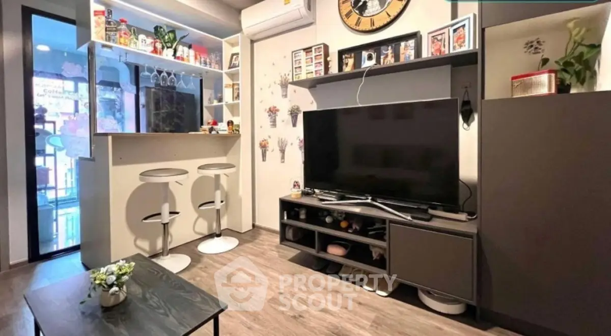 Modern living room with stylish decor and bar area, featuring a large TV and contemporary furniture.