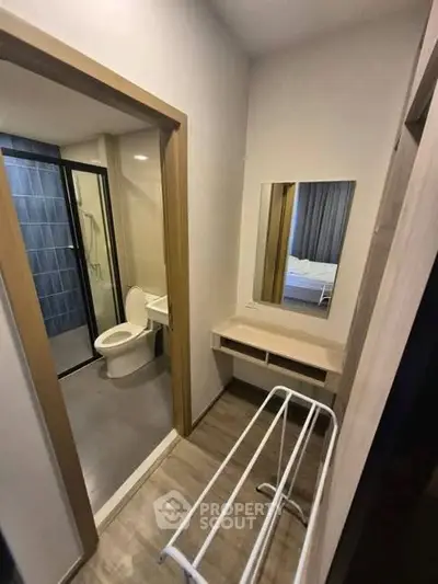 Compact bathroom with modern fixtures and adjacent vanity area