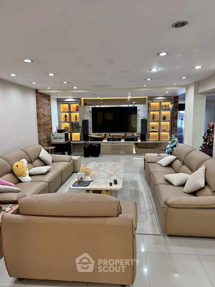 Luxurious living room with elegant beige sofas, modern entertainment center, and ambient lighting.
