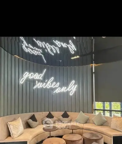 Stylish modern living room with curved sofa and neon sign decor