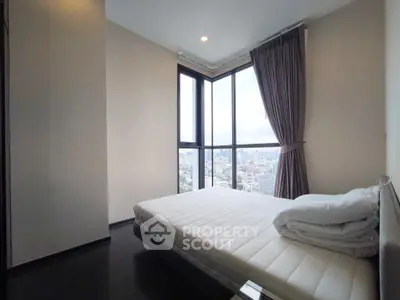 Spacious bedroom with stunning city view from large corner windows, featuring modern decor and ample natural light.