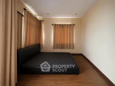 Spacious bedroom with elegant curtains and modern flooring