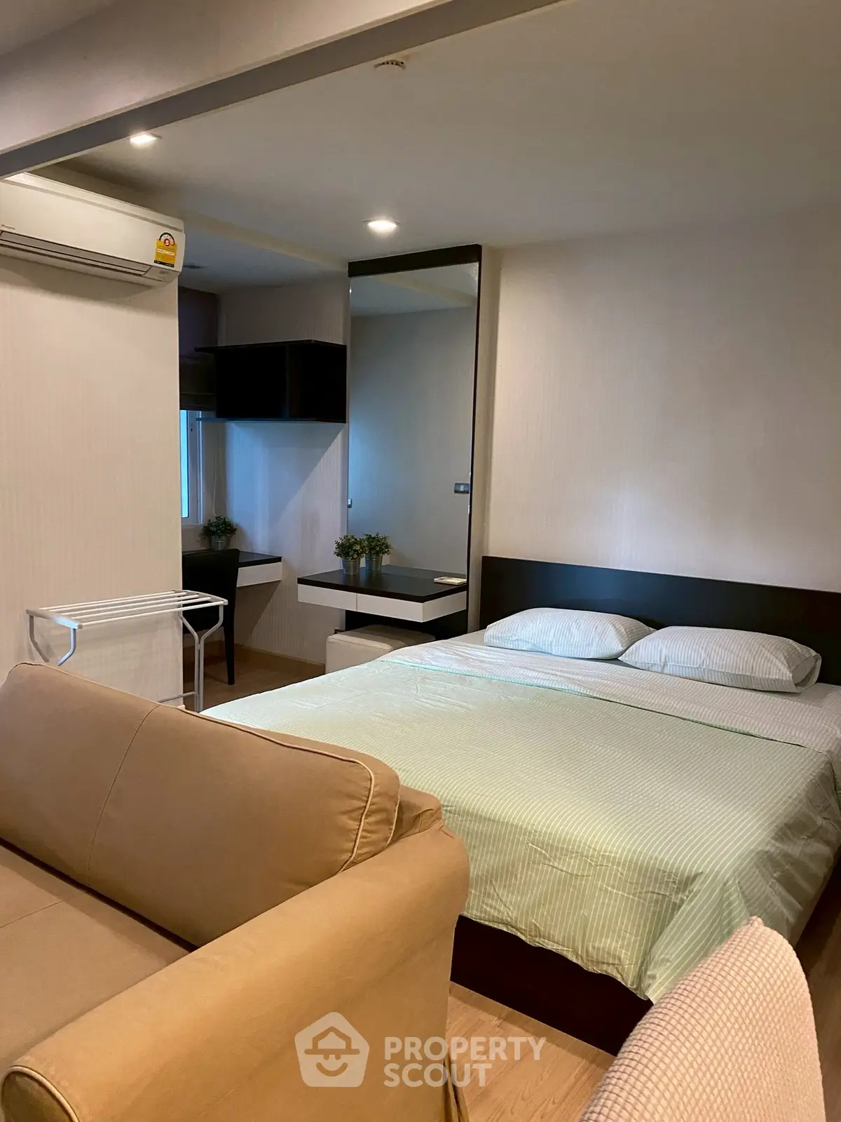 Cozy bedroom with modern decor and comfortable seating area in a stylish apartment.