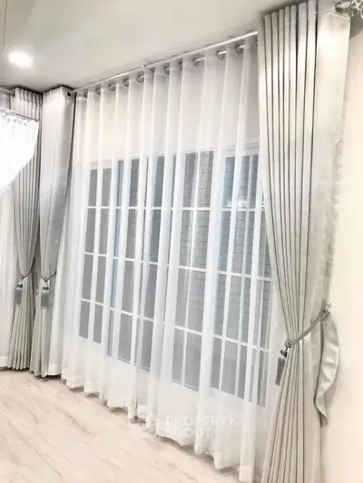 Elegant living room with floor-to-ceiling windows and luxurious curtains