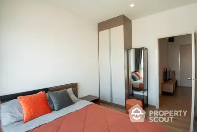 Modern bedroom with a large bed, mirrored wardrobe, and warm wooden flooring, offering a cozy and inviting atmosphere.