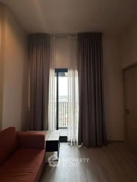 Cozy living room with floor-to-ceiling curtains and a small balcony view.