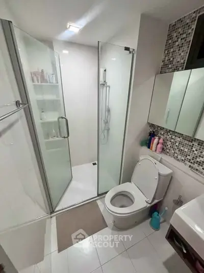 Modern bathroom with glass shower enclosure and sleek fixtures