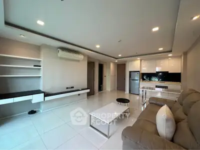 Spacious modern living room with sleek furniture and open kitchen layout