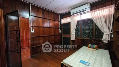 Charming wooden bedroom with air conditioning and natural light, perfect for cozy living.