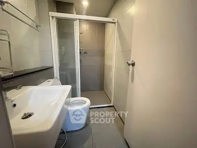 Modern bathroom with sleek shower and contemporary fixtures in a stylish real estate property.
