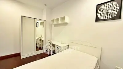 Minimalist bedroom with white furniture and geometric wall art