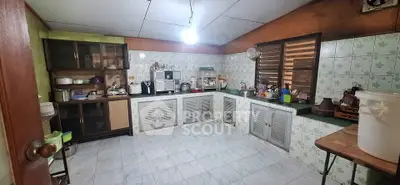Spacious kitchen with vintage charm and ample storage in a cozy home.
