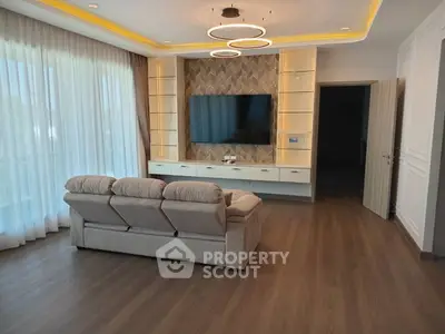 Spacious living room with modern lighting and large TV setup