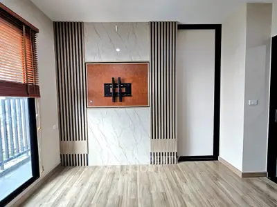 Modern living room with stylish wooden flooring and large window for natural light.