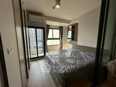 Modern bedroom with large windows and balcony access in urban apartment