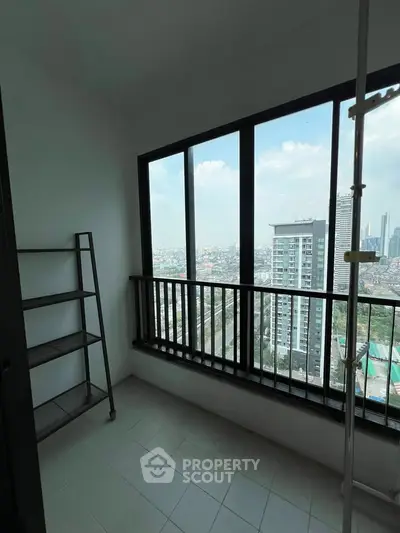 High-rise balcony with stunning cityscape view and ample natural light.