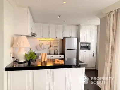 Charming kitchen with sleek black countertops and modern appliances in a cozy open layout