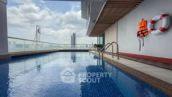Luxurious rooftop pool with stunning city view and safety equipment.