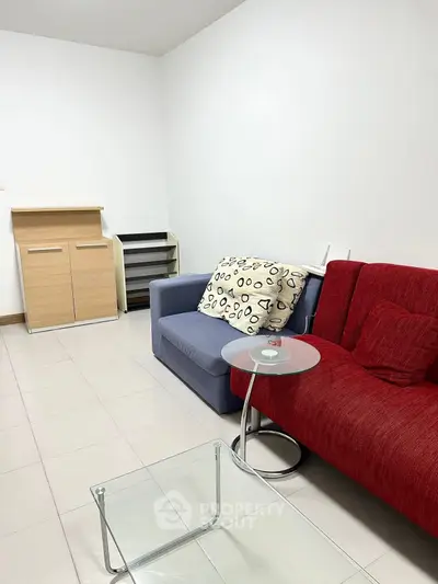 Cozy living room with modern sofas and glass coffee table in a minimalist design.