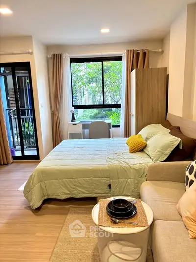 Cozy studio apartment with modern furnishings and garden view.