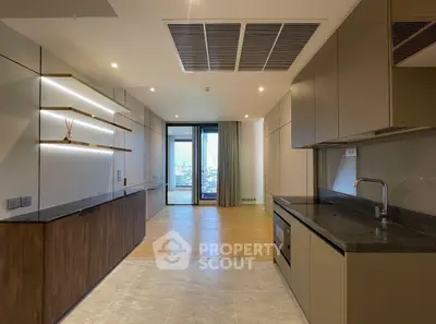 Modern kitchen with sleek cabinetry and open layout, featuring built-in oven and city view.