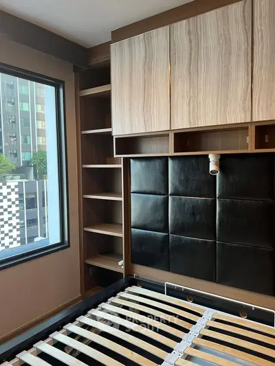 Modern bedroom with built-in storage and city view window.