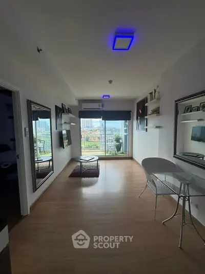 Modern living room with balcony and city view, featuring sleek furniture and ambient lighting.