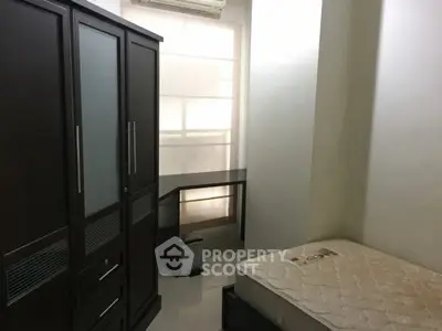 Compact bedroom with wardrobe, desk, and mattress in modern apartment.