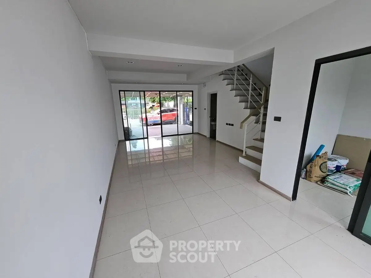 Spacious modern living room with sleek staircase and large windows