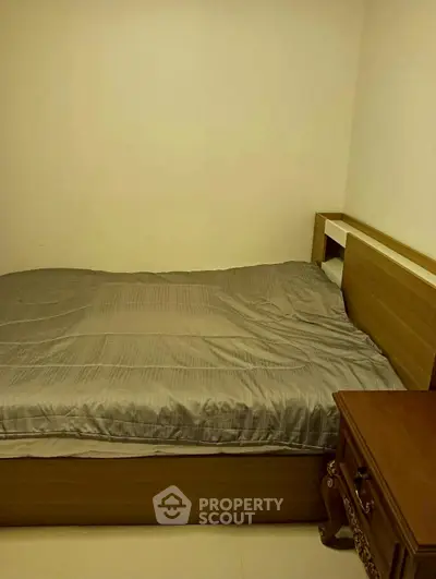 Cozy bedroom with wooden bed and nightstand, perfect for restful nights.