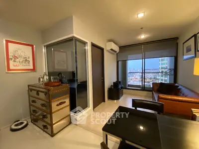 Modern living room with city view, featuring stylish furniture and large windows for natural light.