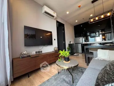 Modern living room with sleek furniture and open kitchen layout in a stylish apartment.