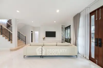 Spacious modern living room with elegant staircase and natural light