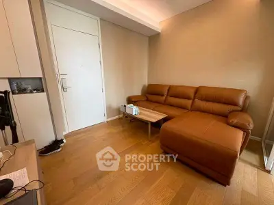 Cozy living room with brown leather sofa and wooden flooring