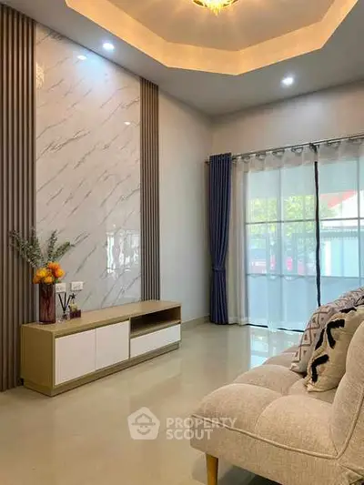 Elegant living room with modern decor and large window for natural light.