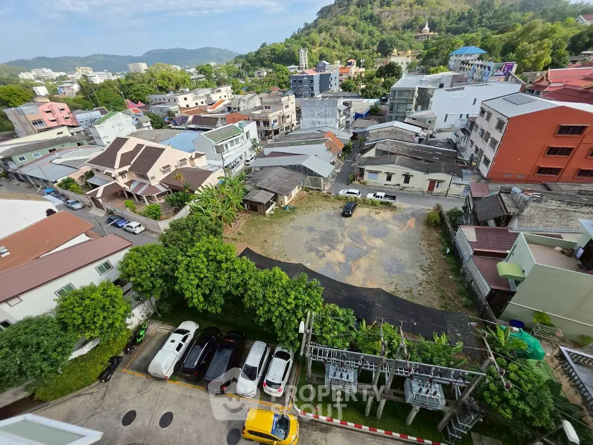 Aerial view of residential neighborhood with lush greenery and parked cars, showcasing urban living.
