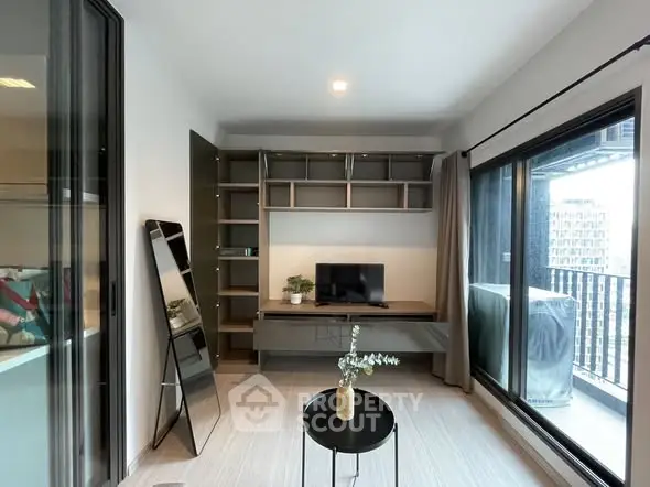 Modern living room with balcony access and stylish shelving unit.