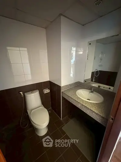 Modern bathroom with sleek design and functional layout, featuring a toilet and sink.